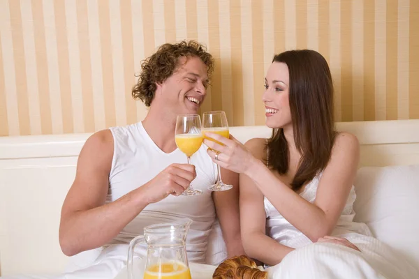 素敵な若いカップル楽しみますシンプルな朝食でベッド — ストック写真