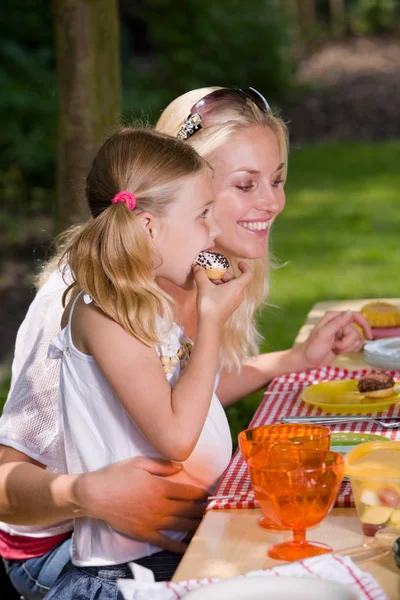 夏の日に外で何かを食べる愛らしい母親と娘 — ストック写真