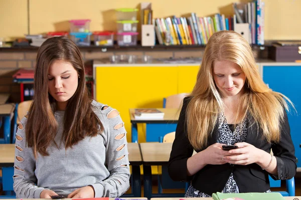 Two Teenage Girls Playing Phones Classroom — Stock Photo, Image