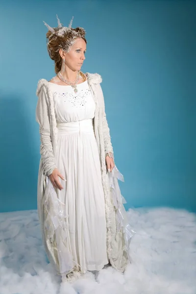 美丽的金发碧眼的女人在白色礼服和长袍站立在雪 — 图库照片