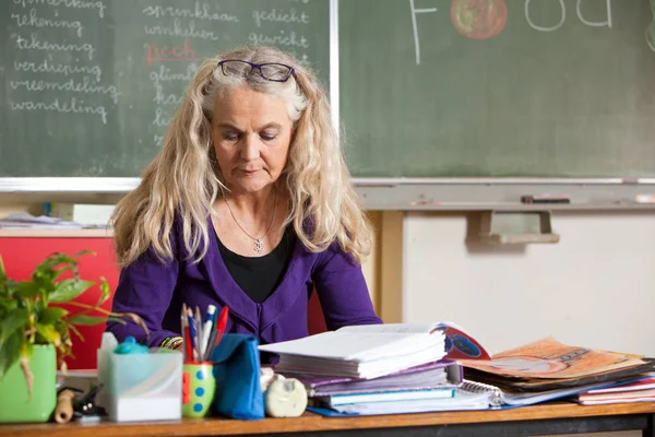 Enseignant Assis Derrière Bureau Pour Vérifier Les Notes Sur Les — Photo