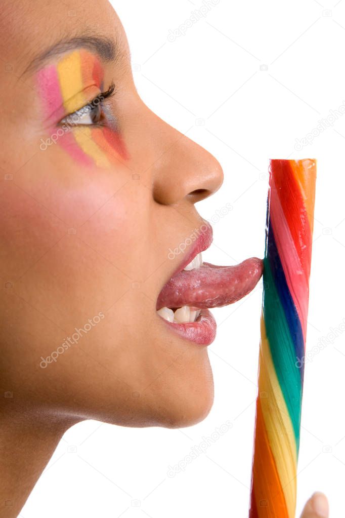 Pretty girl with colorful makeup licking a candystick (focus on tongue, shallow dof)