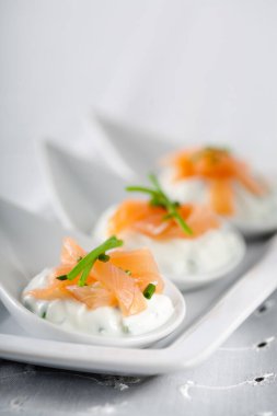 Krem peynirli ve füme somonlu üç kaşık üzerinde lezzetli küçük bir eğlence.