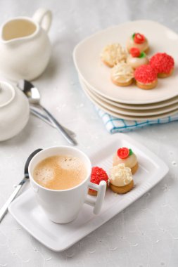 Kahve fincanı ile süslenmiş masa ve badem ezmesi ile küçük tatlılar.