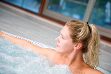 Güzel sarışın kadın spa banyosunda eğleniyor. 