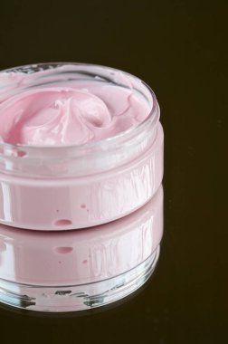 Koyu arkaplanda koyu pembe bir vücut kremi.
