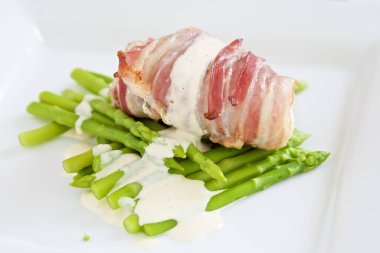 Limonlu mayonez ve kuşkonmaz ile pancetta sarılmış taze fener balığı. Salumi, tuzlanmış domuz eti.