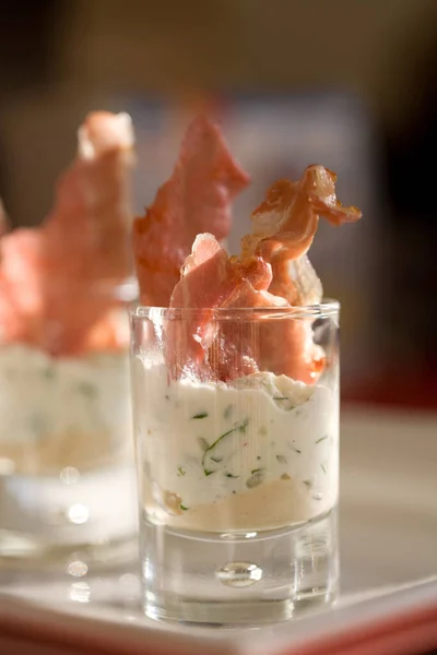 Kleines Glas Mit Kräuterquark Auf Humus Und Knusprigem Backschinken — Stockfoto