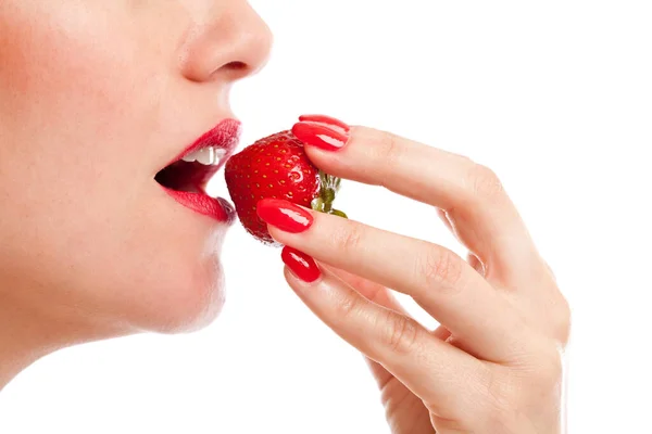 熟した赤いイチゴを一口食べる美しい女性 — ストック写真