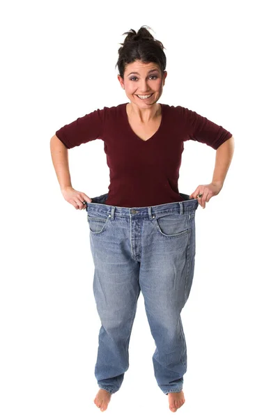 黑发女人撑起她的旧的大牛仔裤 体重减轻 — 图库照片