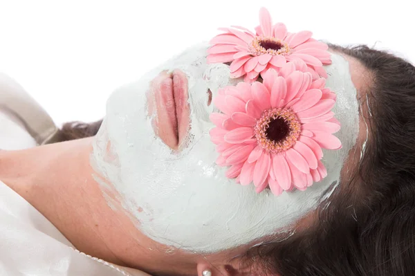 Schöne Frau Liegend Mit Gesichtsmaske Und Gerbera Blumen — Stockfoto