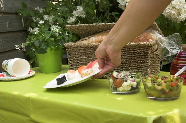 Hand Lägga Till Tallrik Sushi Till Picknickbordet Utomhus — Stockfoto