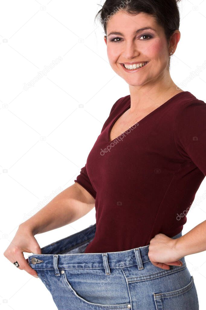 happy brunette woman showing weight loss and wearing huge denim jeans pants 