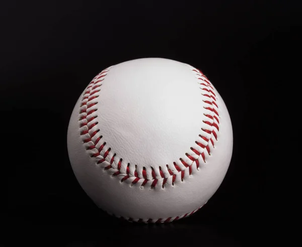 Closeup on a white baseball ball with red thread, black backgrou — Stock Photo, Image