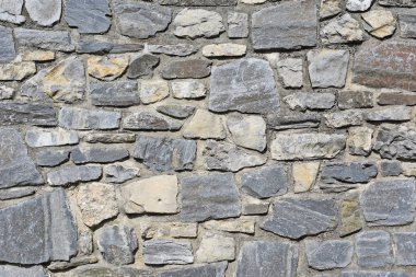 Fragment of a stone wall in a background photo. clipart