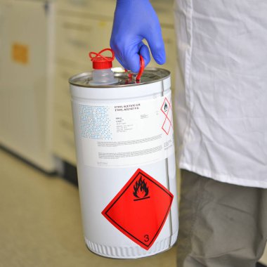 Prague, Çek Cumhuriyeti - 28 Nisan 2018: çalışma yüzeye yakın bir metal canister içinde yanıcı sıvı ile laboratuvar çalışanı. Biyokimya ve Etil asetat G.R. Enstitüsü Organik.