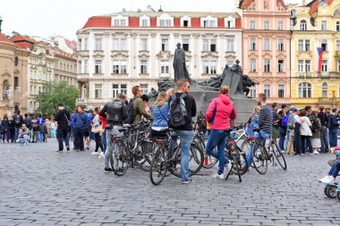 Prag, Çek Cumhuriyeti - 2 Mayıs 2019: Şehir meydanında rehber eşliğinde kiralık bisikletli organize bir turist grubu.