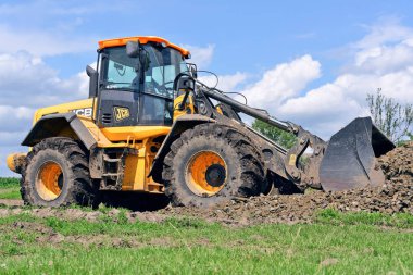 Kalush, Ukrayna 12 Temmuz 2018: Jcb kepçe yükleyici patikadan kasaba Kalush, Ukrayna yakınındaki bir bölümünü onarıyor.