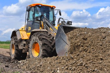 Kalush, Ukrayna 12 Temmuz 2018: Jcb kepçe yükleyici patikadan kasaba Kalush, Ukrayna yakınındaki bir bölümünü onarıyor.