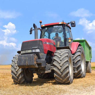 Kalush, Ukrayna 20 Temmuz 2018: Modern traktör şehrin Kalush, Ukrayna tahıl hasat için bir römork ile.