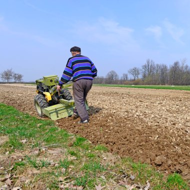 Çiftçi bir bahar alan motor blok işler. 