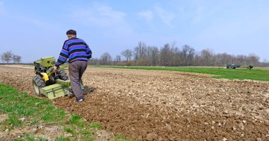 Çiftçi bir bahar alan motor blok işler. 