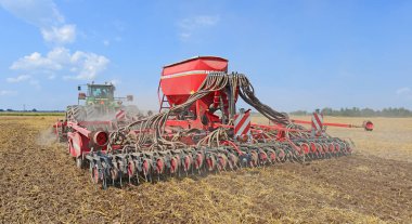 Kalush, Ukrayna - 10 Ağustos 2014: 10 Ağustos 2014 'te Batı Ukrayna' nın Kalush kenti yakınlarındaki tarlada bir ekicisi olan modern John Deere traktörü