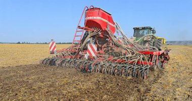 Kalush, Ukraine - August 10 : Modern John Deere tractor with a planter in the field near the town Kalush, Western Ukraine August 10, 2014