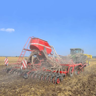 Kalush, Ukraine - August 10 : Modern John Deere tractor with a planter in the field near the town Kalush, Western Ukraine August 10, 2014