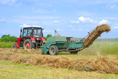 Dolyna, Ukraine - June 1, 2018: Harvesting hay in the fields of organic farm near the town Dolyna, Western Ukraine.