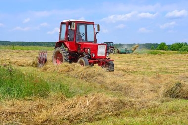 Dolyna, Ukraine - June 1, 2018: Harvesting hay in the fields of organic farm near the town Dolyna, Western Ukraine.