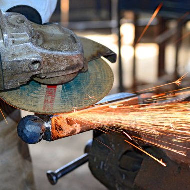 Metali kıvılcımlarla kesen işçi