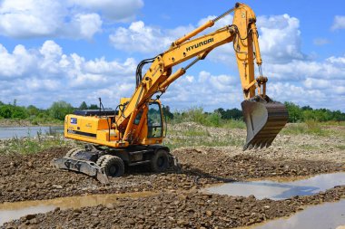 Kalush, Ukrayna - 8 Temmuz 2015: Batı Ukrayna 'nın Kalush kenti yakınlarında inşa edilen koruyucu baraj inşaatı üzerine araba gövdesine kaya yükleme