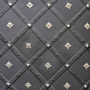 Üzerinde demir dövülmüş elementler olan antik bir binanın ön metal kapısı..