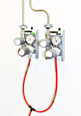 Duvara monte edilmiş iki gaz basıncı düzenleyicisi..
