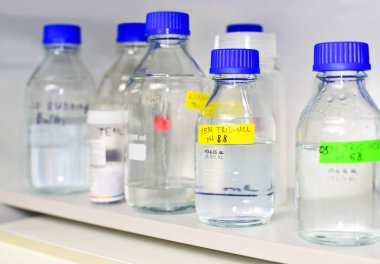 Bottles of buffer solutions stored on a laboratory shelf