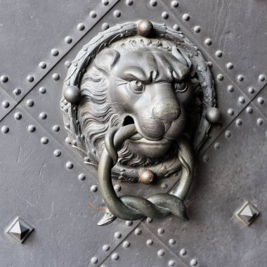 Ancient steel cast door knocker in the form of a lion. Doors, gates.