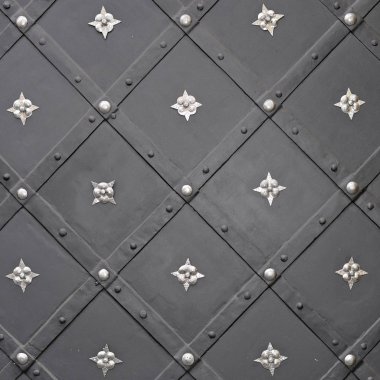 Üzerinde demir dövülmüş elementler olan antik bir binanın ön metal kapısı..