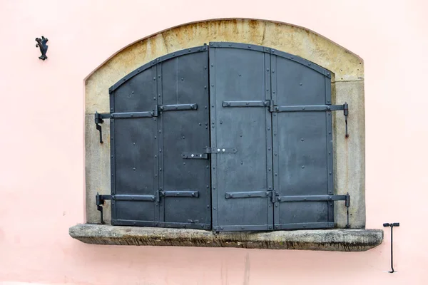 窓に錬鉄製のシャッターがある古い建物の壁の詳細 — ストック写真