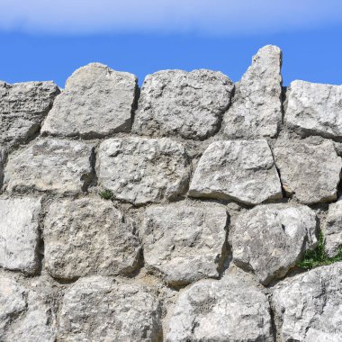 Gökyüzüne karşı taştan yapılmış bir duvar parçası.