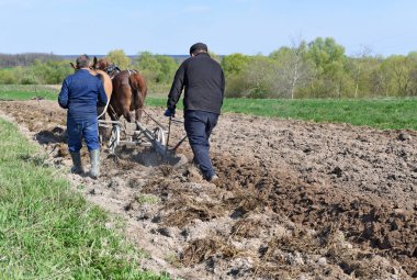Kalush, Ukrayna - 18 Nisan 2017: bir alan tarafından el ile pulluk nadas üzerinde şehrin Kalush, Ukrayna atlı.