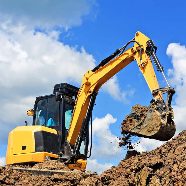 The modern excavator  performs excavation work on the construction site 