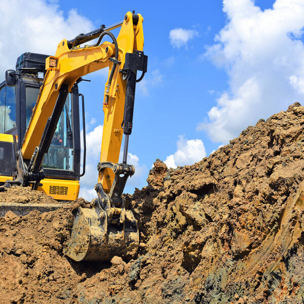The modern excavator  performs excavation work on the construction site 
