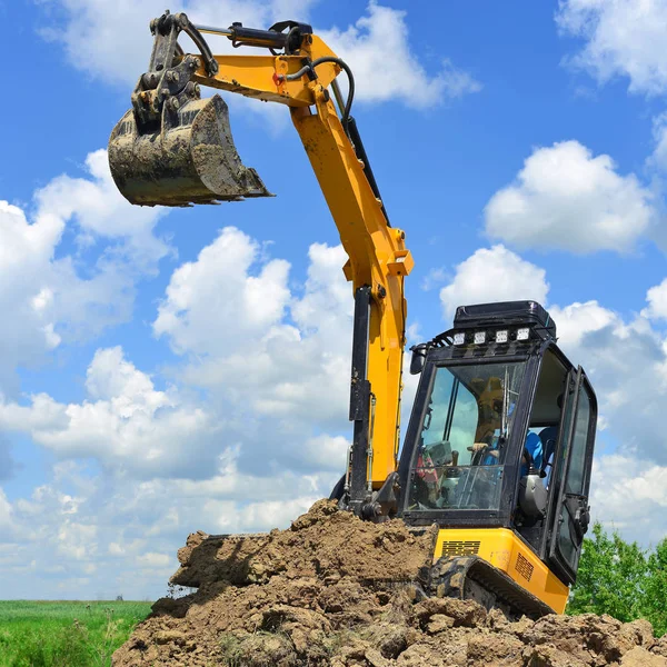 The modern excavator  performs excavation work on the construction site
