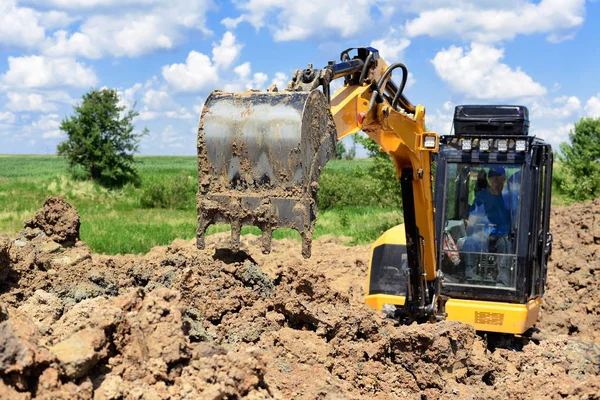 The modern excavator  performs excavation work on the construction site