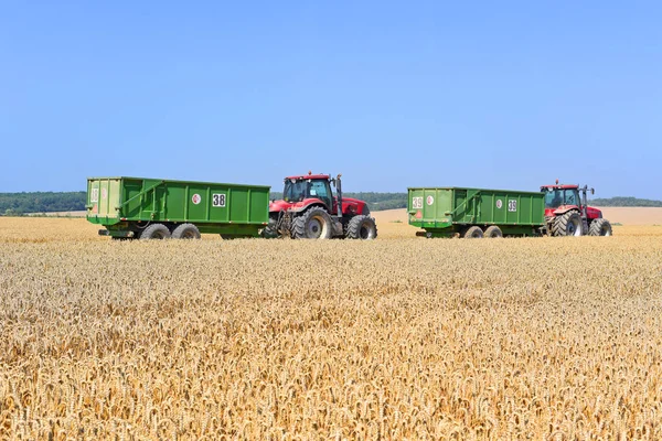 Modern tractors with a trailers for harvesting grain Modern tractor with a trailer for harvesting grain