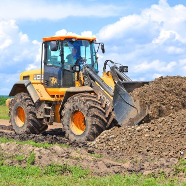 Kalush, Ukrayna 12 Temmuz 2018: Jcb kepçe yükleyici patikadan kasaba Kalush, Ukrayna yakınındaki bir bölümünü onarıyor.