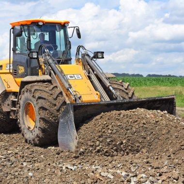 Kalush, Ukrayna 12 Temmuz 2018: Jcb kepçe yükleyici patikadan kasaba Kalush, Ukrayna yakınındaki bir bölümünü onarıyor.