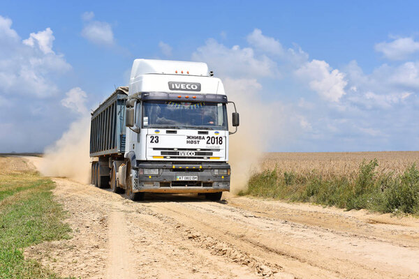 Kalush, Ukraine July 12, 2018: A heavy-duty truck with a grain load on a dirt road through a field near the town of Kalush, Western Ukraine.