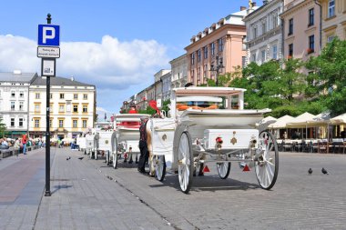 Krakow, Cumhuriyeti Polonya-Temmuz 3, 2017: turist için arabayı durdurmak için bir yer Meryem Ana Kilisesi yakınındaki şehirde Main Market Square üzerinde yürüyor.